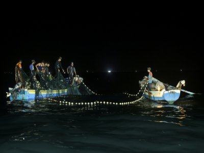 Des pêcheurs palestiniens retirent leur filet des eaux, le 22 septembre 2021 au large des côtes de Gaza - MAHMUD HAMS [AFP]
