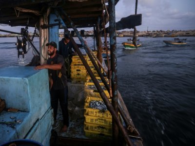 Le pêcheur palestinien Mohammed al-Nahl (c) et son convoi de barques rentre au port de Gaza après une nuit de pêche, le 22 septembre 2021 - MAHMUD HAMS [AFP]