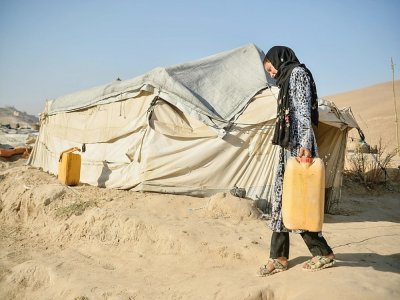 La jeune Habibeh, 12 ans, vendue par sa mère pour 550 dollars, porte un jerrycan dans le camp de déplacés à Qala-i-Naw, le 17 octobre 2021 en Afghanistan - Hoshang Hashimi [AFP]