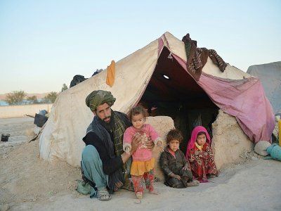 Les fillettes Farishteh, 6 ans, (d) et Shokriya (2g) un an et demi, avec leur père et leur frère, devant leur tente du camp de déplacés de Qala-i-Naw, le 14 octobre 2021 en Afghanistan - Hoshang Hashimi [AFP]