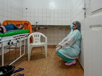 Un soignant près d'un malade du Covid-19 dans un hôpital de fortune à Moju, un secteur reculé de l'Etat de Para, au Brésil, le 8 avril 2021 - Joao Paulo Guimaraes [AFP/Archives]