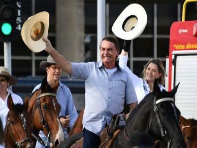 (Le président brésilien Jair Bolsonaro arrive à cheval à une manifestation de fermiers le 15 mai 2021 au Brésil - EVARISTO SA [AFP/Archives]