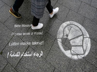 Des messages sur le sol en différentes langues appelant à porter un masque, le 14 octobre 2021 à Berlin - Christof STACHE [AFP/Archives]