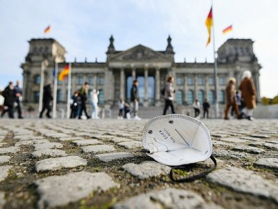 Un masque abandonné sur le sol, devant le Reichstag, le 19 octobre 2021 à Berlin - INA FASSBENDER [AFP/Archives]