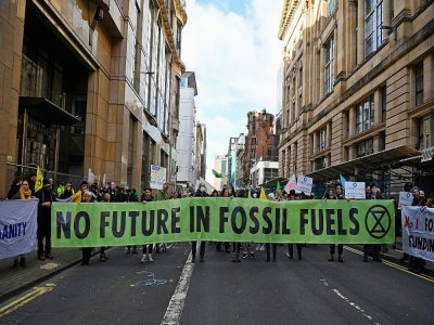 Des militants d'Extinction Rebellion manifestent devant les bureaux de JP Morgan à Glasgow, en pleine COP26, le  2 novembre 2021 - ANDY BUCHANAN [AFP]