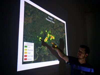 Le biologiste brésilien Fernando Tortato montre sur une carte les zones fréquentées par le jaguar Ousado, le 3 septembre 2021 à Porto Jofre, dans le Pantanal, au Brésil - CARL DE SOUZA [AFP]