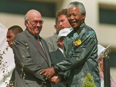 Le président sud-africain Nelson Mandela (D) serre la main de son vice-président Frederik de Klerk, le 27 avril 1996 à Pretoria - WALTER DHLADHLA [AFP/Archives]