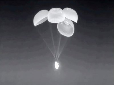 La capsule Dragon de SpaceX transportant le Français Thomas Pesquet et trois autres astronautes, ses quatre parachutes principaux déployés, juste avant son amerrissage de nuit dans le Golfe du Mexique, le 8 novembre 2021 - - [SPACEX/AFP]