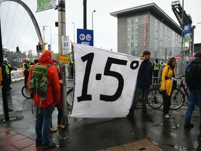 Des manifestants autour d'une banderole appelant à limiter le réchauffement de la planète à +1,5°, en marge de la COP26, à Glagow, en Ecosse - ANDY BUCHANAN [AFP]