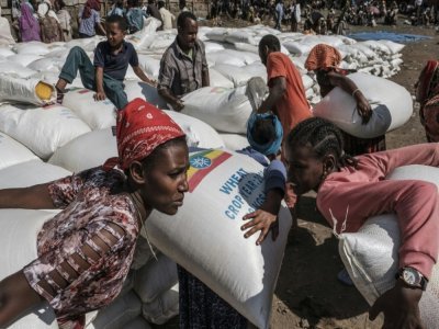 Women carry sacks of wheat during a distribution of food organised by the Ethiopian government in the city of Alamata in December 2020 - EDUARDO SOTERAS [AFP/Archives]