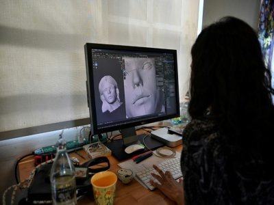Une graphiste numérique travaille le visage de l'influenceur numérique Bangkok Naughty Boo, le 14 octobre 2021 à Bangkok - Lillian SUWANRUMPHA [AFP]