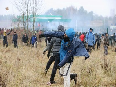 Des migrants jettent des pierres sur les forces de sécurité polonaises à la frontière avec le Belarus, le 16 novembre 2021. - Leonid SHCHEGLOV [BELTA/AFP]