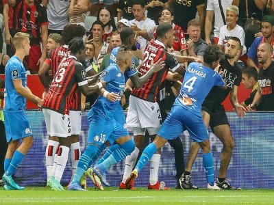 Joueurs marseillais et niçois s'accrochent avec un suppprter de l'OGC Nice lors du match disputé, puis interrompu à l'Allianz Riviera, le 22 août 2021 - Valery HACHE [AFP/Archives]