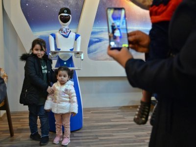 Des enfants posent pour une photo avec un robot-serveur dans le restaurant White Fox, à Mossoul, en Irak, le 17 novembre 2021 - Zaid AL-OBEIDI [AFP]