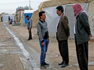 Des membres de la commmunauté yazidie  discutent devant un camp de déplacés à Sharya, à environ 15 kilomètres de la ville de Dohouk, dans le nord de l'Irak, le 20 novembre 2021 - Safin HAMED [AFP]