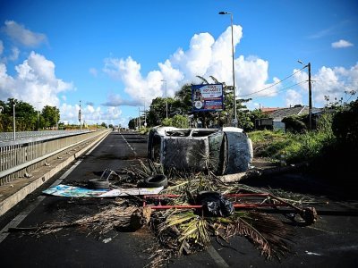 Une voiture incendiée sur un barrage au niveau du rond-point de Perrin aux Abymes, en Guadeloupe le 22 novembre 2022 - Christophe ARCHAMBAULT [AFP]
