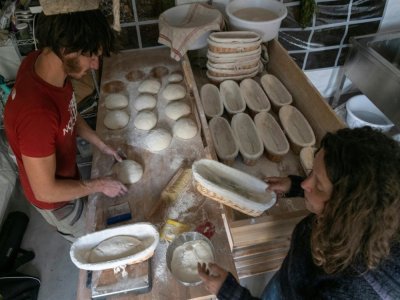 Thibault et Juliette Ricci préparent le pain pour la cuisson à Lavigerie, près de Clermont-Ferrand, le 21 octobre 2021 - Thierry ZOCCOLAN [AFP]