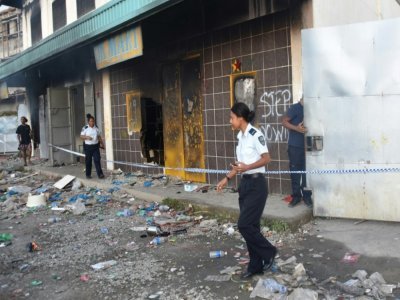 Devant l'immeuble où le corps de trois personnees tuées dans les troubles ont été découverts dans le quartier chinois de Honiara, le 27 novembre 2021 - Charley PIRINGI [AFP]