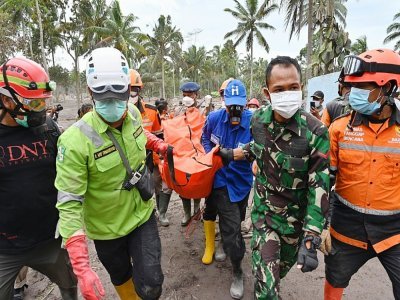 Les secouristes portent le corps d'une victime de l'éruption du volcan Semeru à Sumberwuluh, le 6 décembre 2021 - ADEK BERRY [AFP]