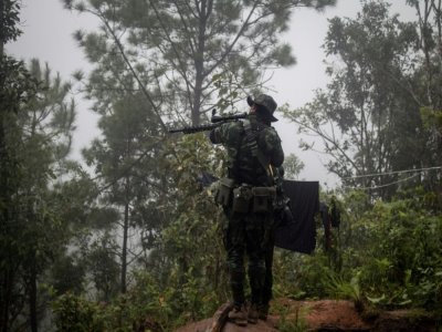 Un rebelle anti-junte pointe son arme pendant un entraînement dans une forêt de l'Etat Karen, en Birmanie, le 16 octobre 2021 - STR [AFP]