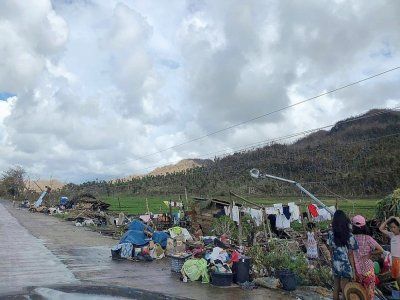 Des habitants de la ville de Dapa, sur l'île de Siargao, rassemblent quelques affaires après la destruction de leurs maisons par le typhon Rai, le 19 décembre 2021 - Roel CATOTO [AFP]