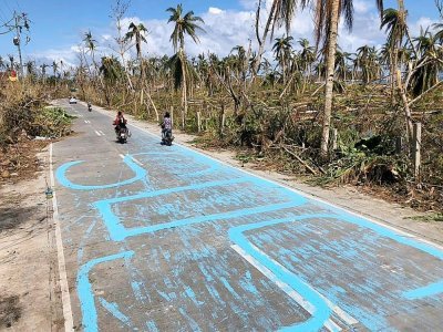Un "S.O.S" a été peint sur une route de General Luna sur l'île de Siargao, le 19 décembre 2021 - Roel CATOTO [AFP]