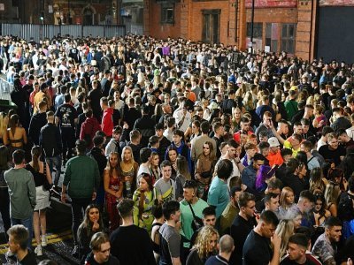 Des fêtards font la queue pour entrer dans un club de Manchester, en Angleterre, le 31 décembre 2021 - Oli SCARFF [AFP]