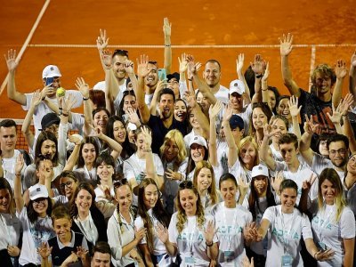 Le Serbe Novak Djokovic (c) pose, entouré des volontaires ayant participé au Balkans l'Adria Tour, un tournoi caritatif itinérant qu'il a organisé, après la finale entre l'Autrichien Dominic Thiem et le Serbe Filip Krajinovic, le 14 juin 2020 à Belgr - Andrej ISAKOVIC [AFP/Archives]