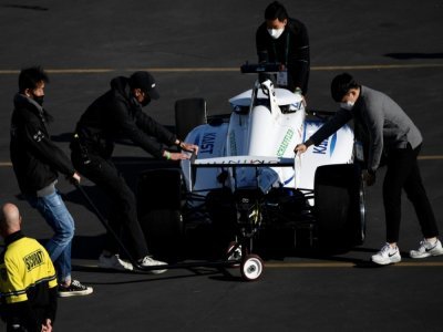 Des membres de l'équipe sud-coréenne KAIST, poussent leur voiture de course autonome, après qu'elle a fait un tête à queue, le 7 janvier 2022 à Las Vegas - Patrick T. FALLON [AFP]