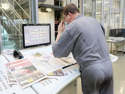 Les techniciens contrôlent la qualité de l'impression du journal avant sa diffusion.