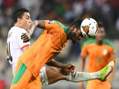 Le milieu de terrain ivoirien Ibrahim Sangaré devance l'attaquant égyptien Mostafa Mohamed, lors de leur 8e de finale de la Coupe d'Afrique des nations, le 26 janvier 2022 à Douala (Camerou) - CHARLY TRIBALLEAU [AFP]