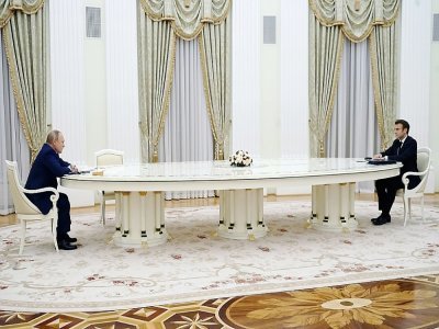 Le président russe Vladimir Poutine (G) reçoit son homologue français Emmanuel Macron au Kremlin le 7 février 2022 pour des entretiens sur l'Ukraine, de part et d'autre d'une longue table pour cause de pandémie - - [SPUTNIK/AFP]