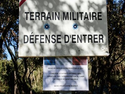 Une affiche invitant à respecter les lieux d'un cimetière sauvage d'enfants harkis situé sur un terrain militaire, le 5 février 2022 à Laudun-L'Ardoise, dans le Gard - Lucie PEYTERMANN [AFP]