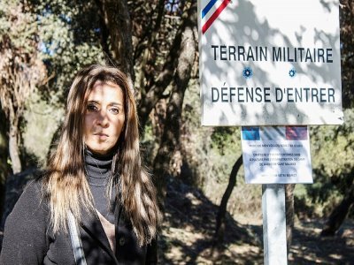 Nadia Ghouafria, fille de Harkis et membre de l'association locale de l'Aracan, devant l'entrée d'un terrain militaire, site d'un cimetière sauvage où sont enterrés des enfants harkis, le 5 février 2022 à Laudun-L'Ardoise, dans le Gard - Lucie PEYTERMANN [AFP]