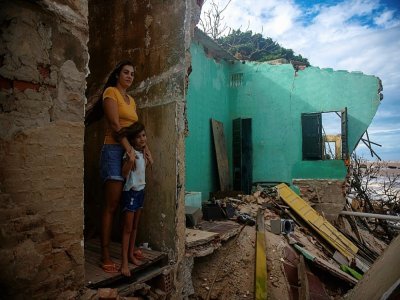 Une femme et sa fille dans les ruines de leur maison sur la plage d'Atafona, le 7 février 2022 au Brésil - MAURO PIMENTEL [AFP]