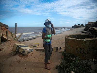 Une femme sur la plage d'Atafona, cité balnéaire qui disparaît peu à peu sous l'océan, le 7 février 2022 au Brésil - MAURO PIMENTEL [AFP]