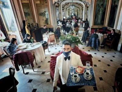 Un serveur apporte des expressos à des clients du café Gambrinus de Naples, le 13 février 2022 en Italie - Alberto PIZZOLI [AFP]