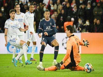 L'attaquant du Paris Saint-Germain Kylian Mbappé marque l'unique but du match face au gardien de but belge du Real Madrid, Thibaut Courtois, lors de leur 8e de finale aller de la Ligue des Champions, le 15 février 2022 au Parc des Princes - Alain JOCARD [AFP]