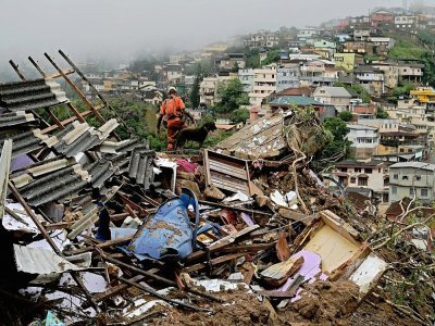 Un membre des équipes de secours cherche des survivants à Petropolis, au Brésil, le 16 février 2022 - CARL DE SOUZA [AFP]