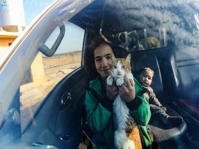 Une jeune déplacée syrienne tient son chat à l'intérieur d'une voiture avant de partir pour un complexe résidentiel, construit près de la ville d'al-Bab, le 9 février 2022 en Syrie - Bakr ALKASEM [AFP]