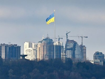 Un grand drapeau ukrainien flotte au dessus de Kiev attaqué par les forces russes, le 26 février 2022 - GENYA SAVILOV [AFP]
