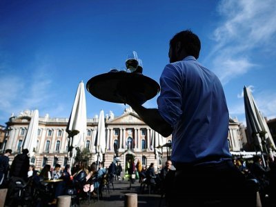 Un serveur apporte des boissons à des clients à la terrasse d'un café place du Capitole, le 25 février 2022 à Toulouse - Valentine CHAPUIS [AFP]
