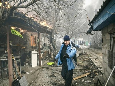 Un homme marche au millieu des maisons en feu à Irpin, en Ukraine, le 4 mars 2022 - Aris Messinis [AFP]