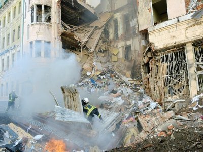 Des pompiers essayent d'éteindre un incendie dans un immeuble touché par un tir russe à Kharkiv, en Ukraine, le 14 mars 2022 - Sergey BOBOK [AFP]