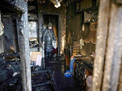 Une habitante se tient à l'intérieur de son appartement ravagé par des tirs, à Kiev le 15 mars 2022 - FADEL SENNA [AFP]