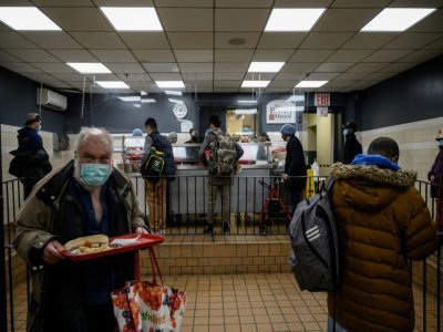 Quelques personnes sans abris de New York se voient offrir des repas par l'association Bowery Mission, à New York, le 16 mars 2022 - Ed JONES [AFP]