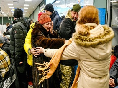 Des habitants aident une vieille femme fuyant Marioupol, arrivée à Zaporojie, dans le sud-est de l'Ukraine, le 22 mars 2022 - Dmytro Smolienko [Ukrinform/AFP/Archives]