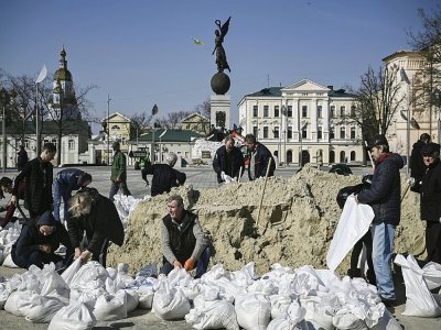 Des employés municipaux remplissent des sacs de sable pour protéger les monuments de la ville de Kharkiv, le 26 mars 2022 - Aris Messinis [AFP]