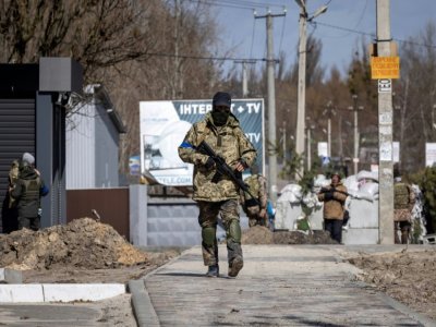 Un soldat patrouille à un poste de contrôle à Stoyanka, près Kiev, le 27 mars 2022 - FADEL SENNA [AFP]