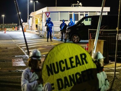 Des gendarmes en position derrière des militants de Greenpeace qui bloquent l'entrée du chantier du réacteur EPR à Flamanville, le 31 mars 2022 dans la Manche - Sameer Al-DOUMY [AFP]
